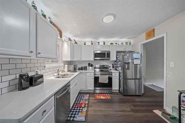 3620 S Northern Blvd, Independence, MO 64052 - kitchen with stainless steel appliances, a sink, a textured ceiling, dark wood-style floors, and decorative backsplash