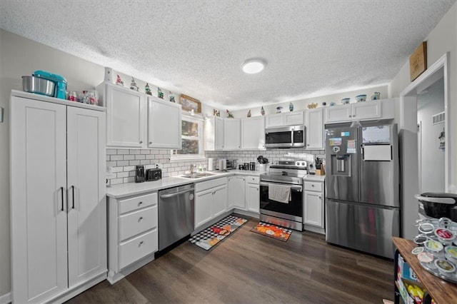 3620 S Northern Blvd, Independence, MO 64052 - kitchen featuring appliances with stainless steel finishes, a sink, a textured ceiling, dark wood-style flooring, and light countertops