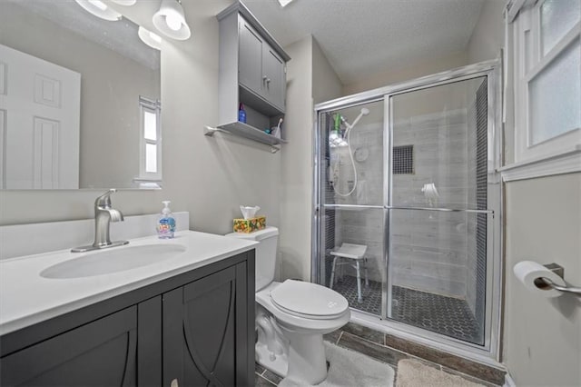 3620 S Northern Blvd, Independence, MO 64052 - bathroom featuring vanity, toilet, a stall shower, a textured ceiling, and tile patterned floors