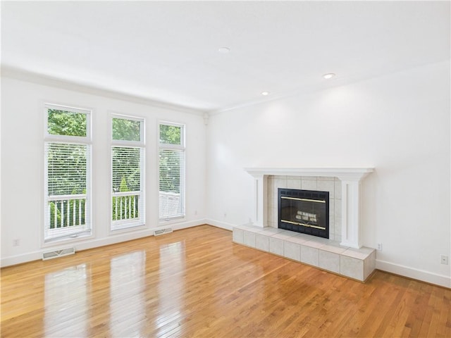 503 Quail Trl, Warrensburg, MO 64093 - unfurnished living room featuring light wood-type flooring, a tiled fireplace, and recessed lighting