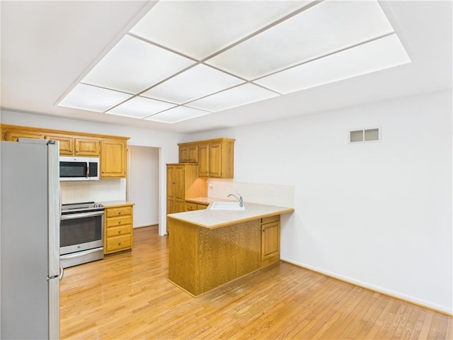 503 Quail Trl, Warrensburg, MO 64093 - kitchen featuring freestanding refrigerator, electric range, a peninsula, light wood finished floors, and light countertops