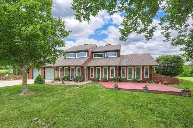 2000 E 187th St, Belton, MO 64012 - view of front facade featuring driveway, a chimney, a front yard, a deck, and an attached garage