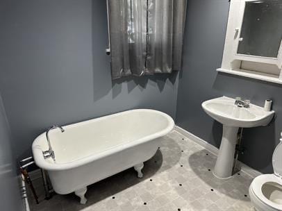 1331 S 17th St, Saint Joseph, MO 64507 - bathroom with a freestanding bath, toilet, and baseboards