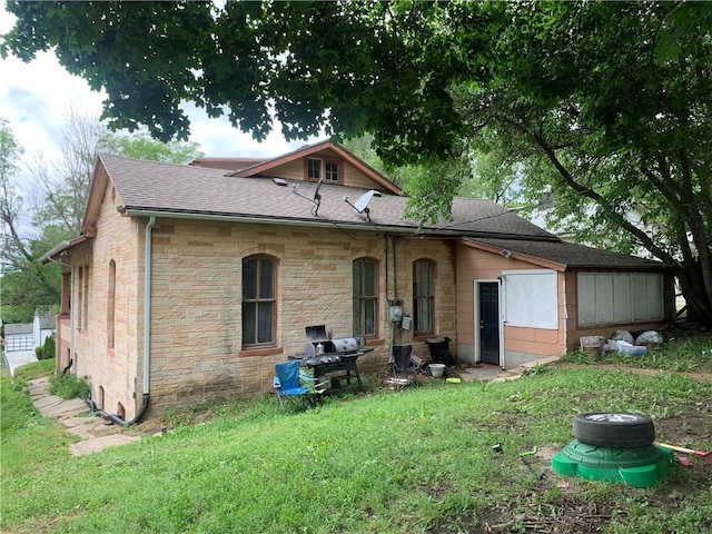 1331 S 17th St, Saint Joseph, MO 64507 - back of property with stone siding, a shingled roof, and a lawn
