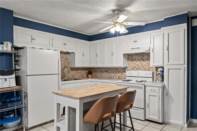 2912 W 75th St, Prairie Village, KS 66208 - kitchen featuring white appliances, under cabinet range hood, a ceiling fan, light tile patterned flooring, and white cabinets