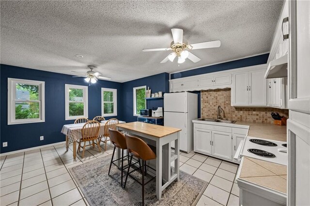 2912 W 75th St, Prairie Village, KS 66208 - kitchen featuring white appliances, healthy amount of natural light, tasteful backsplash, a ceiling fan, and a textured ceiling
