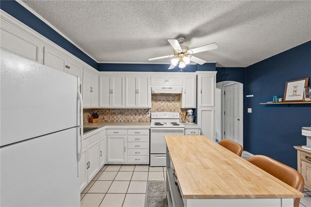 2912 W 75th St, Prairie Village, KS 66208 - kitchen with white appliances, under cabinet range hood, wood counters, ceiling fan, and white cabinetry