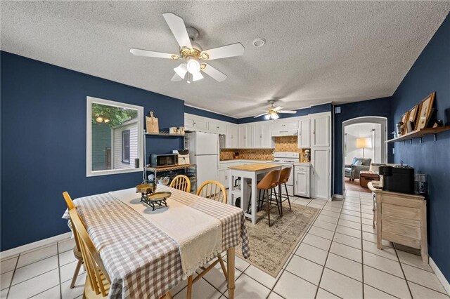 2912 W 75th St, Prairie Village, KS 66208 - dining room with light tile patterned floors, a ceiling fan, a textured ceiling, and arched walkways