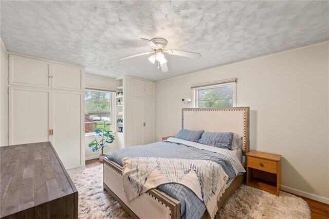 2912 W 75th St, Prairie Village, KS 66208 - bedroom with light wood finished floors, a ceiling fan, and a textured ceiling