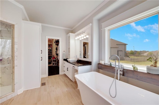 905 SE Wood Ridge Ct, Blue Springs, MO 64014 - bathroom with a marble finish shower, a freestanding bath, a spacious closet, vanity, and crown molding