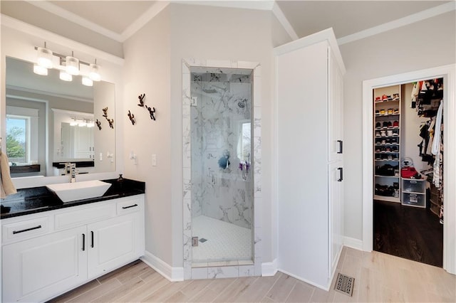 905 SE Wood Ridge Ct, Blue Springs, MO 64014 - bathroom featuring a marble finish shower, wood finished floors, vanity, ornamental molding, and a spacious closet