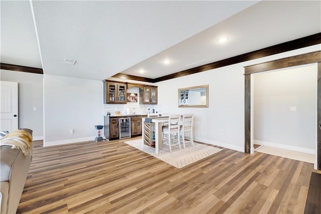 905 SE Wood Ridge Ct, Blue Springs, MO 64014 - indoor wet bar featuring wine cooler, baseboards, light wood-style floors, decorative backsplash, and recessed lighting
