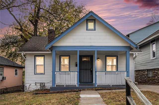 4224 Monroe Ave, Kansas City, MO 64130 - bungalow-style home with covered porch and a chimney