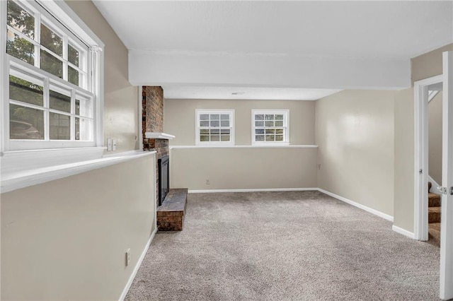 838 E 125th Ter, Olathe, KS 66061 - unfurnished living room with carpet flooring, a fireplace, and baseboards
