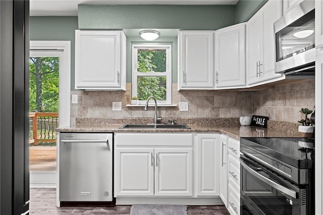 16807 E 3rd Ter N, Independence, MO 64056 - kitchen featuring stainless steel appliances, white cabinetry, tasteful backsplash, and wood finished floors