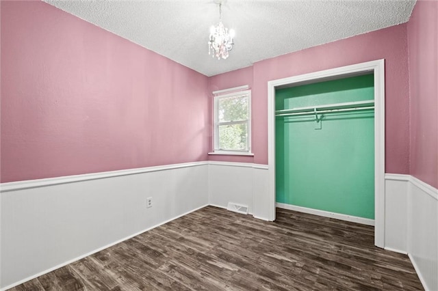 16807 E 3rd Ter N, Independence, MO 64056 - unfurnished bedroom featuring dark wood-style flooring, a textured ceiling, a chandelier, and a closet