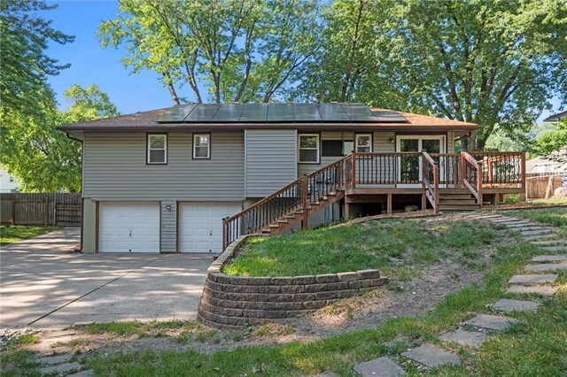 16807 E 3rd Ter N, Independence, MO 64056 - rear view of house with stairs, an attached garage, driveway, and solar panels