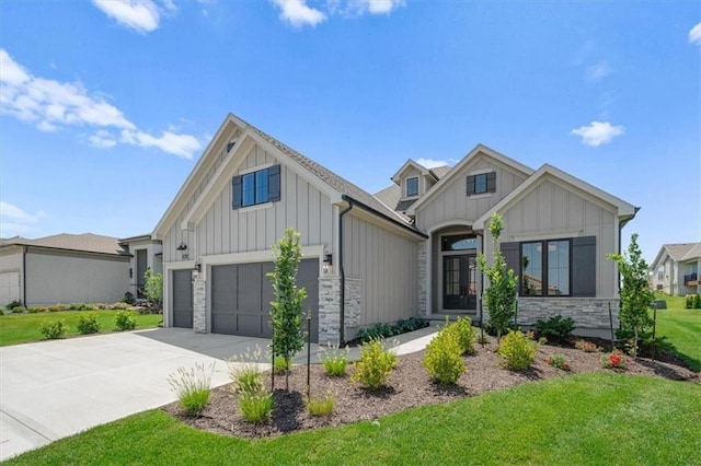 8013 Payne St, Shawnee, KS 66220 - modern inspired farmhouse featuring board and batten siding, stone siding, an attached garage, concrete driveway, and a front yard