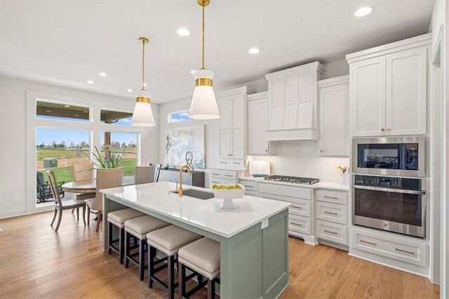 8013 Payne St, Shawnee, KS 66220 - kitchen featuring appliances with stainless steel finishes, a sink, light countertops, an island with sink, and recessed lighting