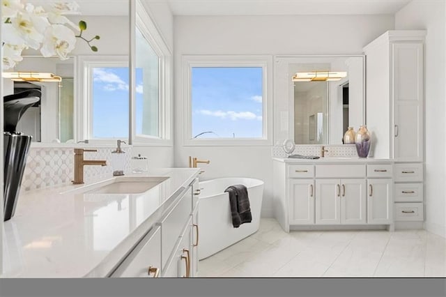 8013 Payne St, Shawnee, KS 66220 - bathroom with two vanities, a soaking tub, marble finish floors, tasteful backsplash, and a shower