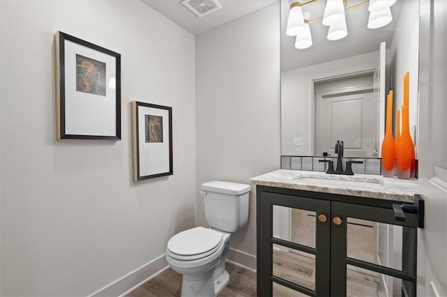 8013 Payne St, Shawnee, KS 66220 - bathroom with toilet, wood finished floors, vanity, and baseboards