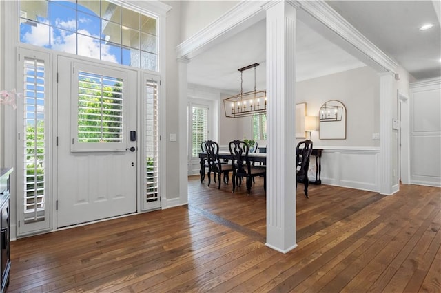 15618 Meadowbrook Ct, Raymore, MO 64083 - foyer featuring dark wood-style floors, a chandelier, and decorative columns