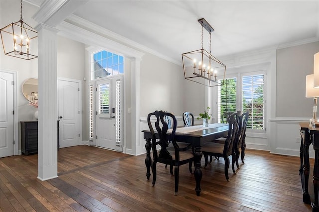 15618 Meadowbrook Ct, Raymore, MO 64083 - dining space with a chandelier, dark wood-type flooring, crown molding, and decorative columns
