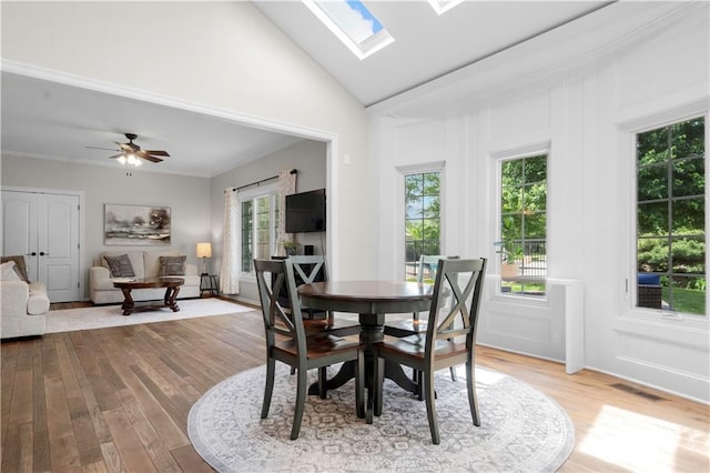 15618 Meadowbrook Ct, Raymore, MO 64083 - dining area with wood finished floors, a skylight, a ceiling fan, and high vaulted ceiling