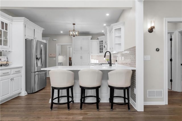 15618 Meadowbrook Ct, Raymore, MO 64083 - kitchen with stainless steel fridge with ice dispenser, a peninsula, white cabinets, decorative backsplash, and recessed lighting