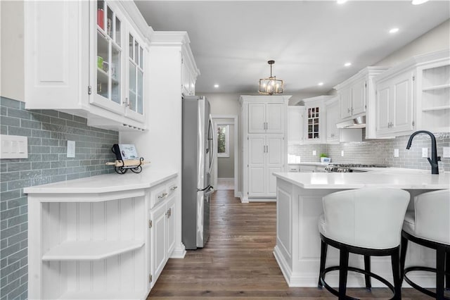 15618 Meadowbrook Ct, Raymore, MO 64083 - kitchen with open shelves, freestanding refrigerator, a peninsula, light countertops, and recessed lighting