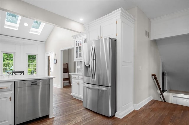 15618 Meadowbrook Ct, Raymore, MO 64083 - kitchen with appliances with stainless steel finishes, a skylight, wood finished floors, white cabinets, and light countertops