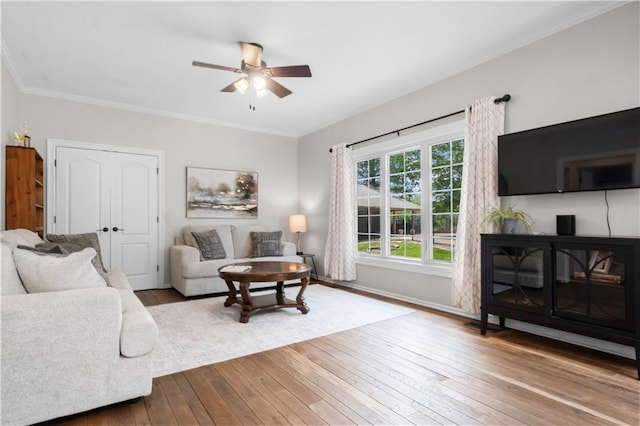 15618 Meadowbrook Ct, Raymore, MO 64083 - living room with wood-type flooring, a ceiling fan, baseboards, crown molding, and a glass covered fireplace
