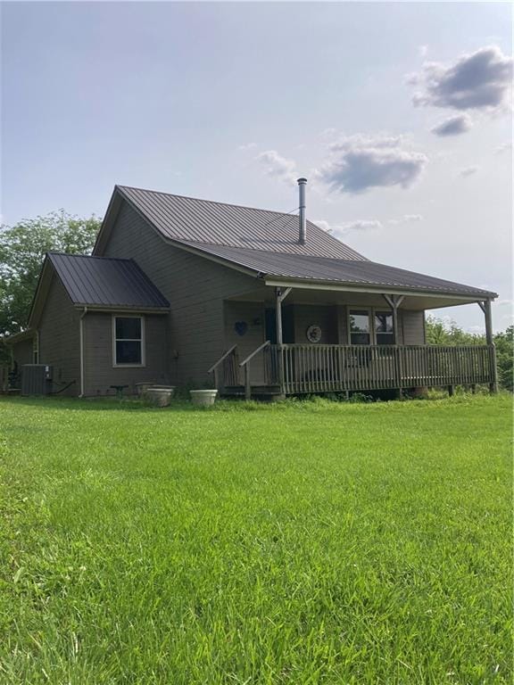 31122 Nelson Rd, Drexel, MO 64742 - back of house with metal roof, a lawn, covered porch, and cooling unit