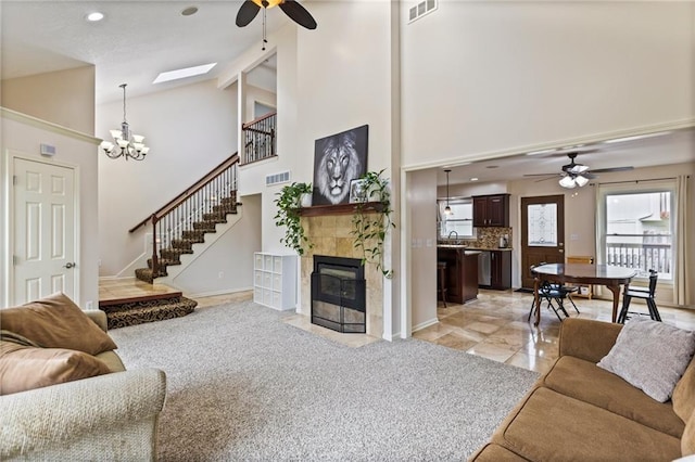 14401 Craig Ave, Grandview, MO 64030 - living area featuring ceiling fan, high vaulted ceiling, a tile fireplace, stairway, and baseboards