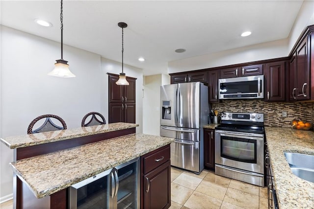 14401 Craig Ave, Grandview, MO 64030 - kitchen featuring appliances with stainless steel finishes, a kitchen island, decorative backsplash, pendant lighting, and light stone countertops