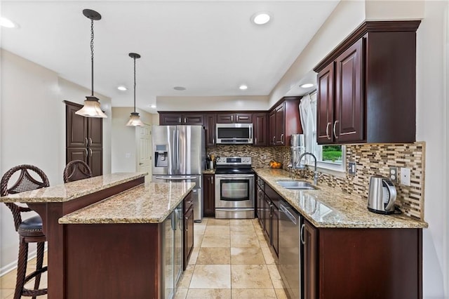 14401 Craig Ave, Grandview, MO 64030 - kitchen featuring appliances with stainless steel finishes, a sink, decorative backsplash, a breakfast bar area, and a kitchen island