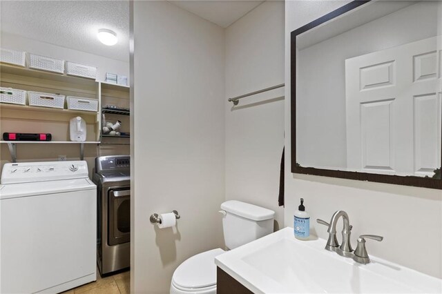 14401 Craig Ave, Grandview, MO 64030 - bathroom with independent washer and dryer, toilet, tile patterned flooring, and vanity