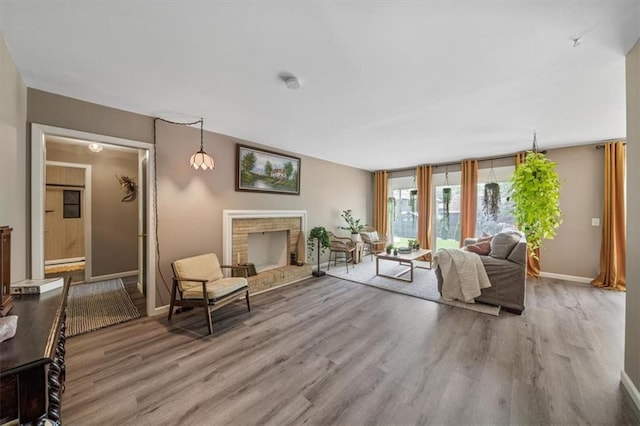 811 W 86th Ter, Kansas City, MO 64114 - living area with wood finished floors, a fireplace, and baseboard heating