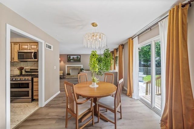 811 W 86th Ter, Kansas City, MO 64114 - dining room with a chandelier and light wood-style flooring
