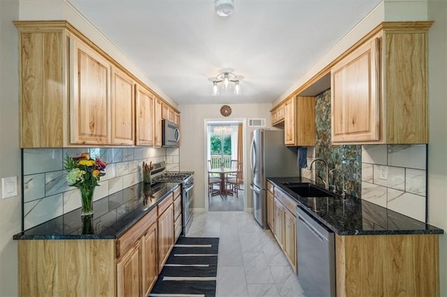 811 W 86th Ter, Kansas City, MO 64114 - kitchen featuring appliances with stainless steel finishes, backsplash, dark stone countertops, and light marble finish flooring