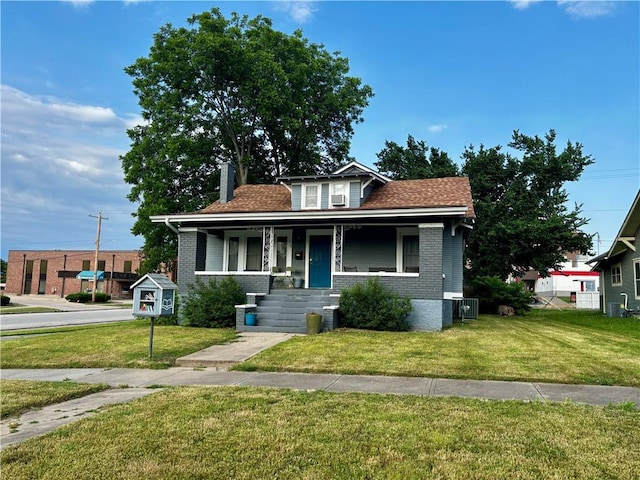 418 N 8th St, Independence, KS 67301 - bungalow with covered porch, a front lawn, and brick siding