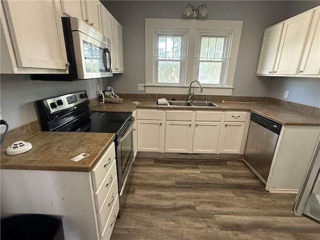 418 N 8th St, Independence, KS 67301 - kitchen featuring stainless steel appliances, a sink, white cabinetry, and dark wood finished floors