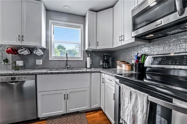 7041 Garnett St, Shawnee, KS 66203 - kitchen featuring appliances with stainless steel finishes, a sink, light stone counters, and backsplash