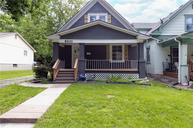 4231 Wyoming St, Kansas City, MO 64111 - view of front facade featuring a porch, a front yard, and brick siding
