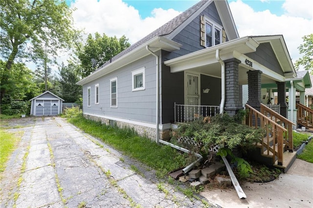 4231 Wyoming St, Kansas City, MO 64111 - view of home's exterior featuring covered porch, an outdoor structure, asphalt driveway, and a detached garage