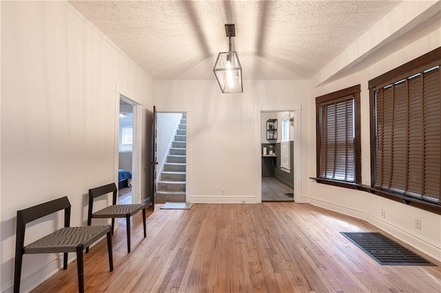 4231 Wyoming St, Kansas City, MO 64111 - sitting room featuring wood finished floors, a textured ceiling, stairway, and baseboards