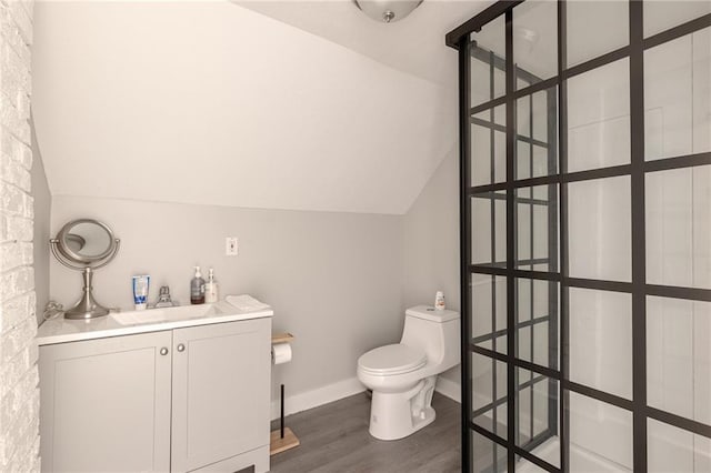 4231 Wyoming St, Kansas City, MO 64111 - bathroom with wood finished floors, toilet, lofted ceiling, vanity, and baseboards