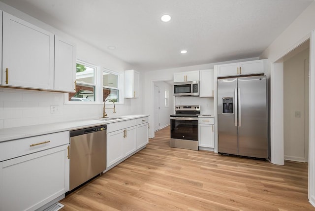 23852 Haigwood Rd, Tonganoxie, KS 66086 - kitchen with appliances with stainless steel finishes, a sink, decorative backsplash, white cabinetry, and light countertops