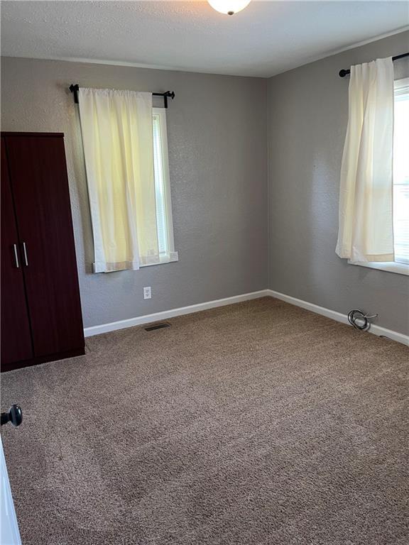 106 S Washington Ave, Knob Noster, MO 65336 - unfurnished bedroom featuring carpet floors and baseboards