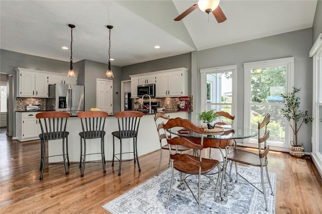 14169 W 115th Ter, Olathe, KS 66062 - kitchen with appliances with stainless steel finishes, dark countertops, white cabinets, vaulted ceiling, and recessed lighting